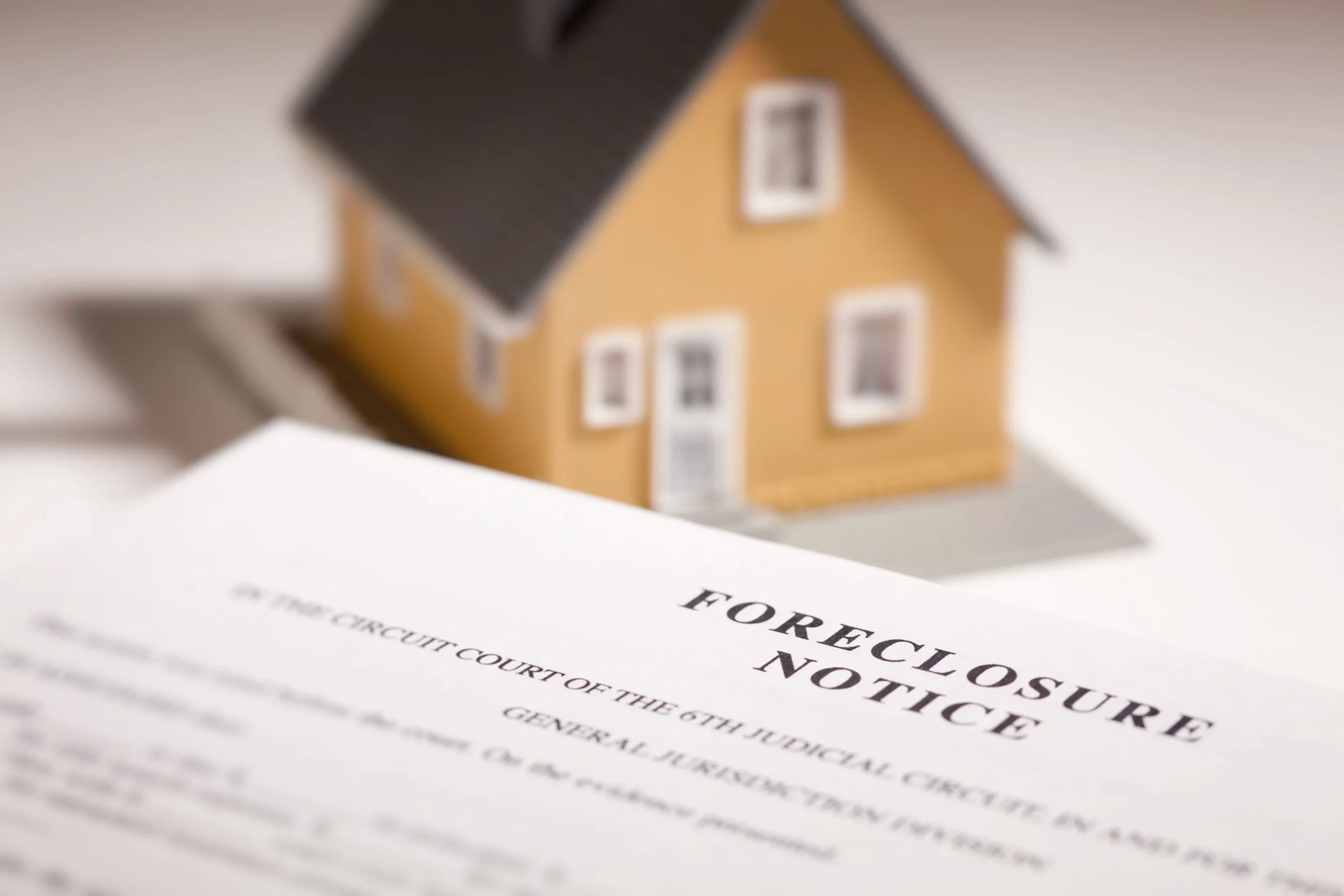 Foreclosure notice with a house model representing how bankruptcy can help stop foreclosure in Missouri