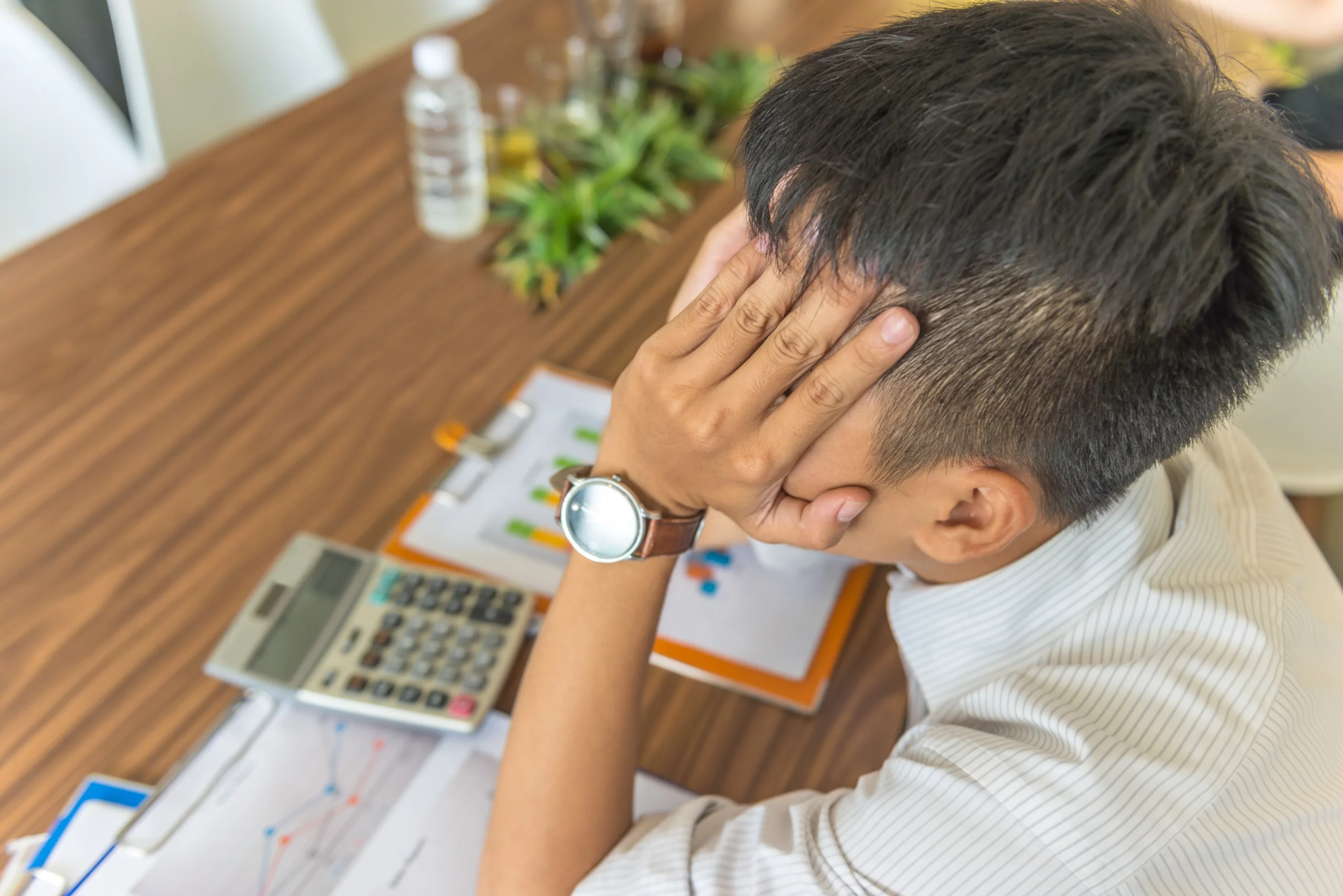 Stressed man reviewing financial documents and comparing Chapter 7 vs. Chapter 13 bankruptcy options