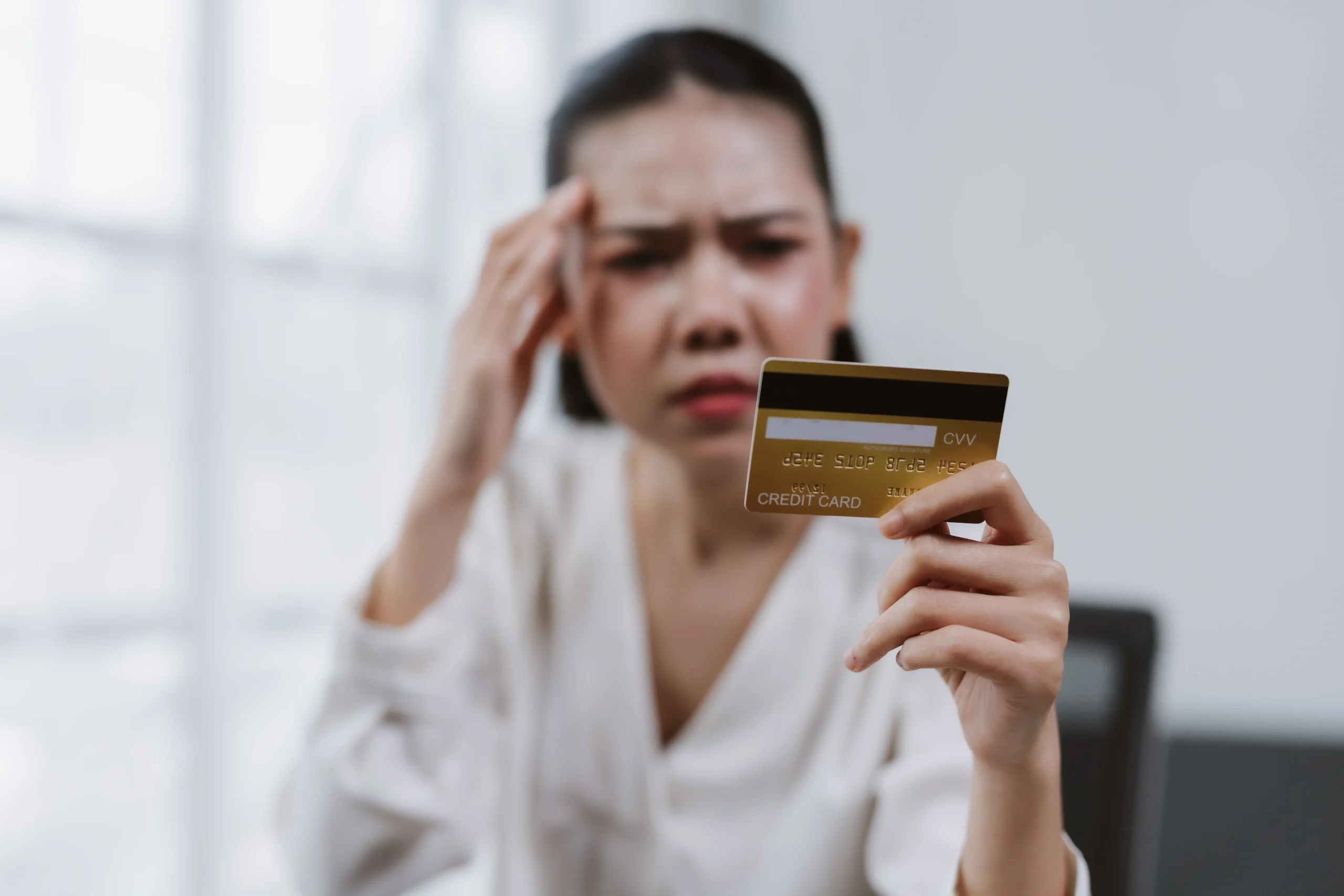 Woman reviewing credit card while facing financial stress and credit card debt in Missouri